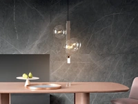 Lampada a sospensione verticale Bon Ton composta da lame metalliche in acciaio spazzolato sulle quali le sfere di vetro che formano i paralumi, realizzate in vetro trasparente sono disposte in ordine irregolare di Bonaldo